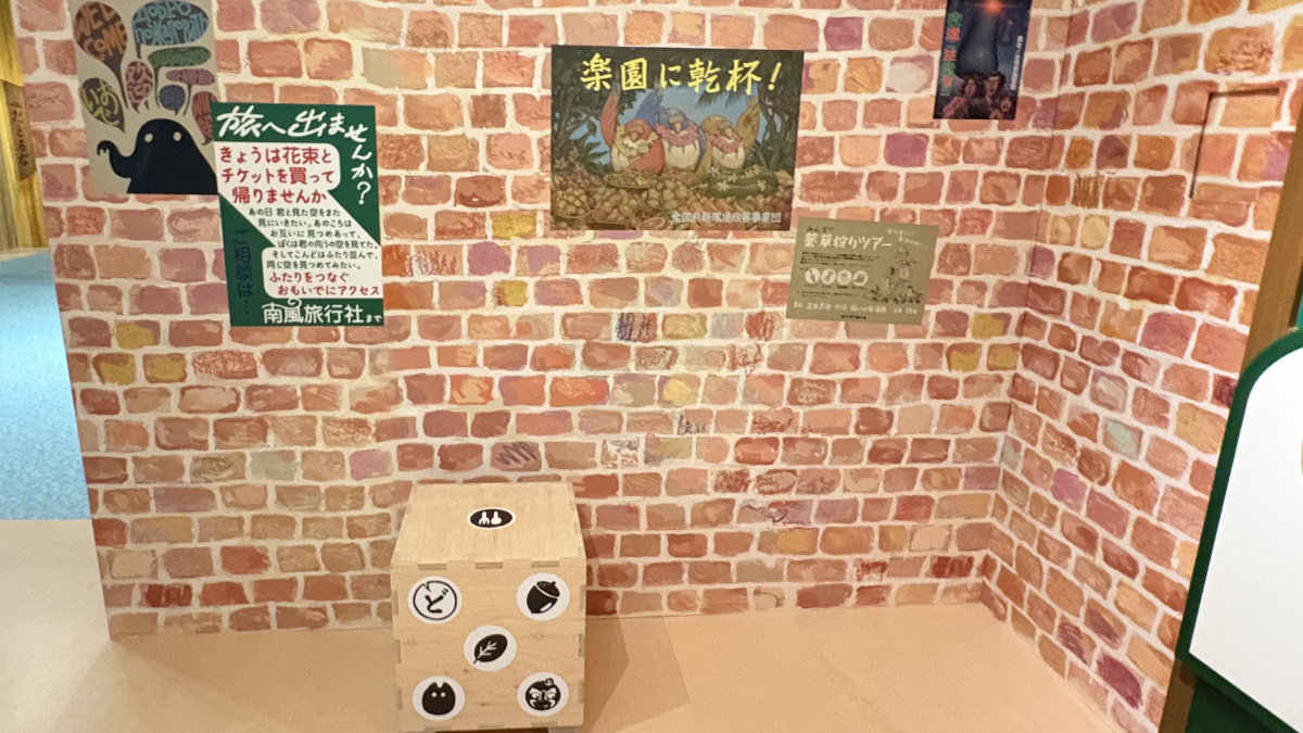 レンガの壁の前に置かれた小さなジブリパークのサイコロ